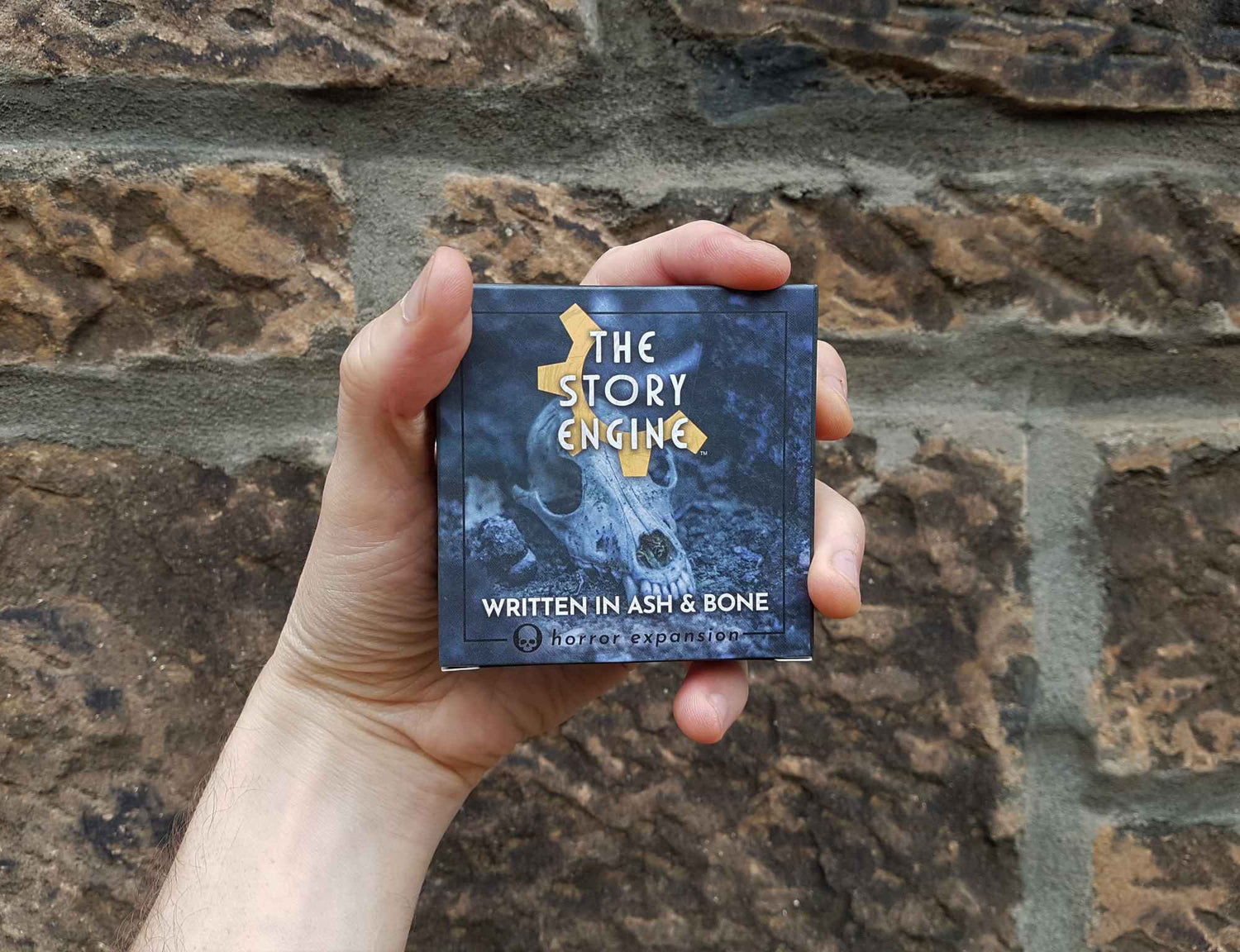 Horror writing prompts expansion held in front of a brick wall