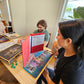 Three TTRPG players sitting at the gaming table playing D&D with The Story Engine Deck of D&D prompts with a DM screen up